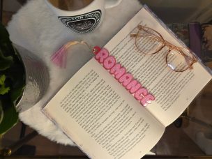 Lesezeichen mit dem Text Romance. Darauf sind rosane Herzen.