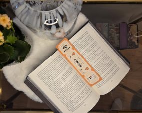 Orangenes Lesezeichen, das wie eine Eintrittskarte aussieht, mit Halloween Elementen, wie einem Geist und einer Fledermaus.