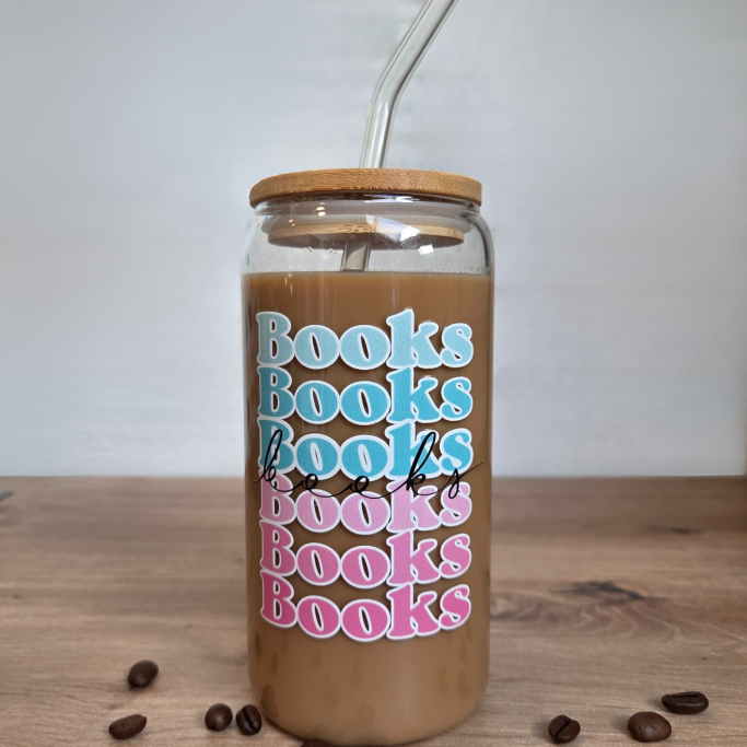 Glas mit der Aufschrift "Books" in verschiedenen Blau- und Rosatönen. Gefüllt mit Kaffee.
