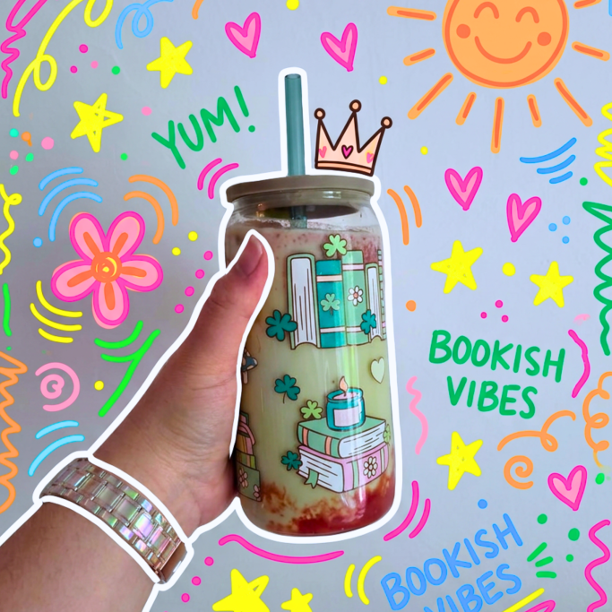 Glas mit der Aufschrift "Books" in verschiedenen Blau- und Rosatönen. Gefüllt mit Kaffee.